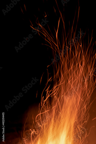 Sparks from a fire against a dark night background. Bonfire. Vertical photo