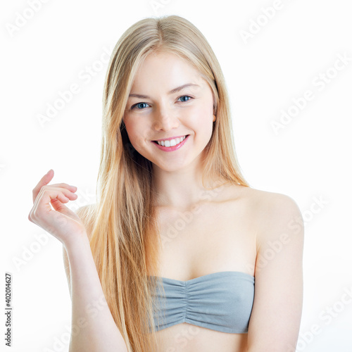 Attractive young caucasian woman with long blond hair happy smiling and posing at studio over white background
