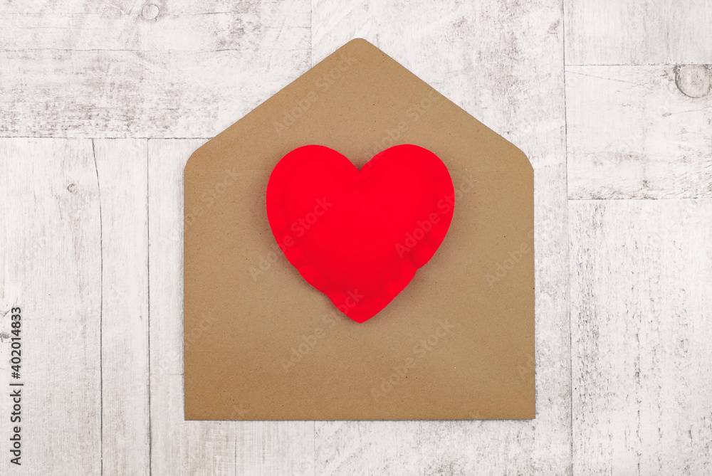 Red heart on envelope for holidays on wooden background, vintage style, top view. Red heart on envelope for holidays on wooden background, vintage style, top view.