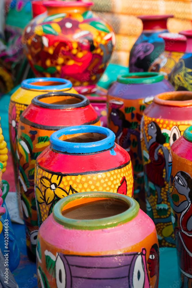 Beautiful painted colorful terracotta pots, works of handicraft, for sale during Handicraft Fair in Kolkata. Vertical image.