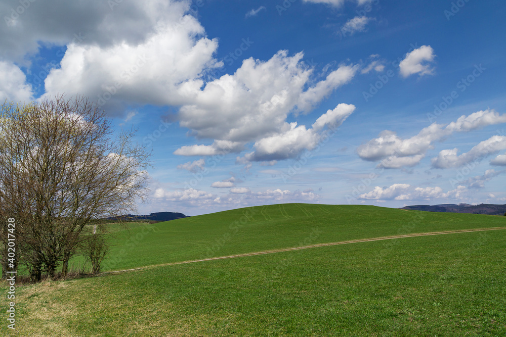 Schmallenberg - View to hilly meadow at springtime mood with awesome clouds / Germany Schmallenberg - View to hilly meadow at springtime mood with awesome clouds / Germany