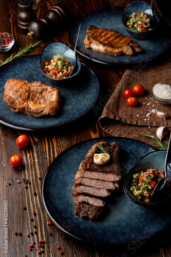 Assortment of juicy appetizing steaks on a wooden table of a fancy restaurant