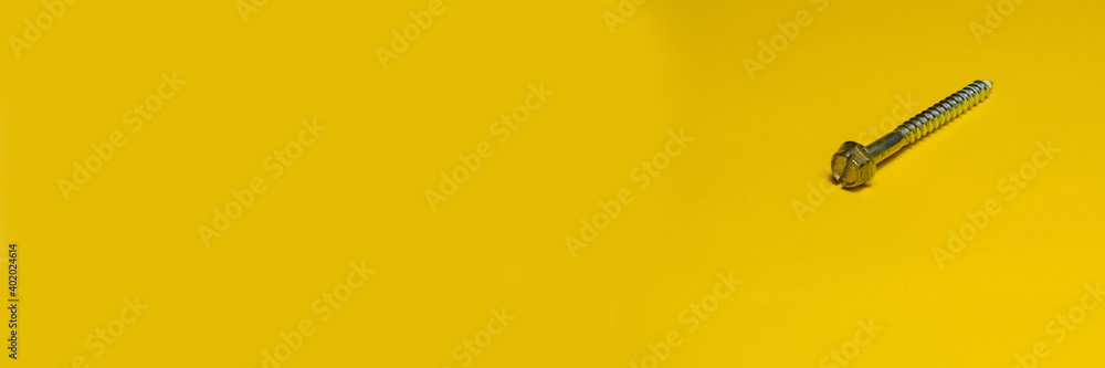 Screw isolated on yellow background. Banner panoramic. Copy space for text message. High resolution sharp photo. Screw isolated on yellow background. Banner panoramic. Copy space for text message. High resolution sharp photo.