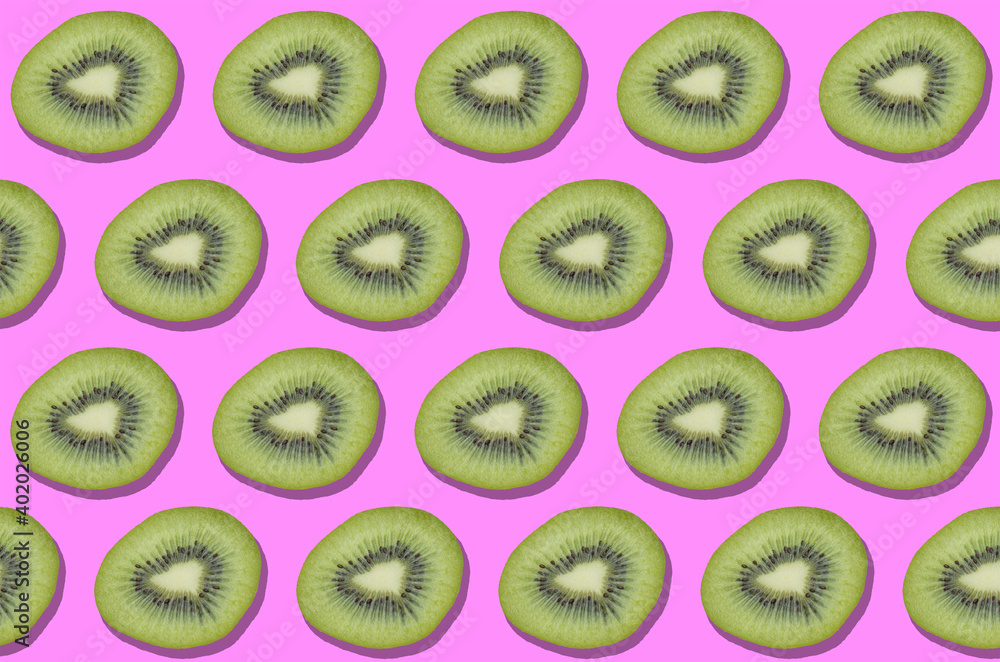 Fototapeta premium Colorful kiwis decorative pattern on pink background. Exotic fruits. Vegan, vegetarian and healthy lifestyle concept. Top view.