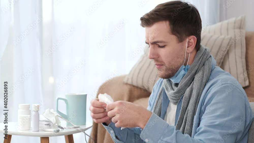 Man blowing his nose while lying sick in bed. Health care, flu,covid-19 concept. Man blowing his nose while lying sick in bed. Health care, flu,covid-19 concept.