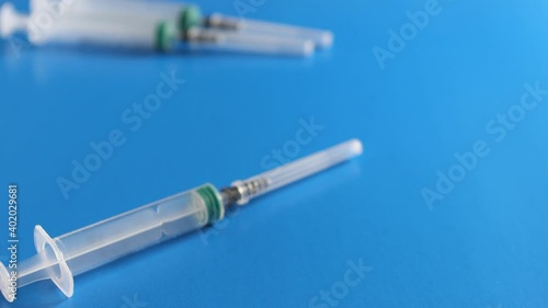 The doctor's gloved hand places a syringe and an ampoule of vaccine on the table. The concept of vaccination of the population.