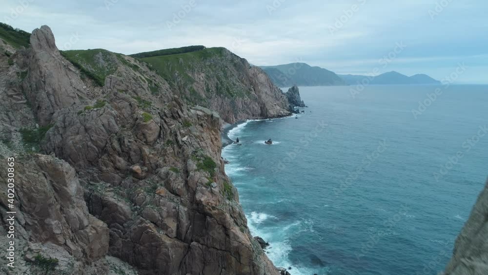Extreme flight inside cliff peaks on steep coast Primorsky Krai Russia unique natural dramatic epic landscape. Sharp kekura stones, ocean waves of blue sea beat. Mystical untouched wilderness footage Extreme flight inside cliff peaks on steep coast Primorsky Krai Russia unique natural dramatic epic landscape. Sharp kekura stones, ocean waves of blue sea beat. Mystical untouched wilderness footage