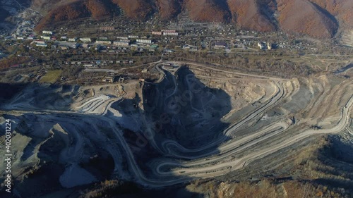 Aerial sideways epic open mining and chemical company combine deep quarry on background of city. Russia Far East grand industrial landscape. Processing of boron ores is only one in world. Stock photo