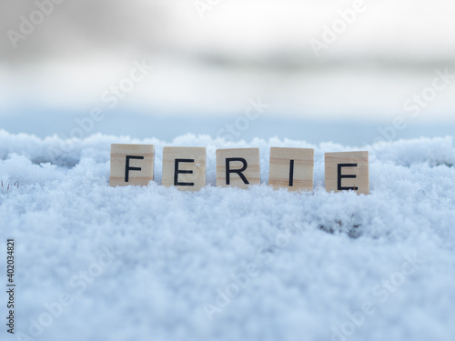 ferie - napis z drewnianych kostek, ułożony w śniegu, czas wolny, przerwa zimowa od szkoły, język polski 