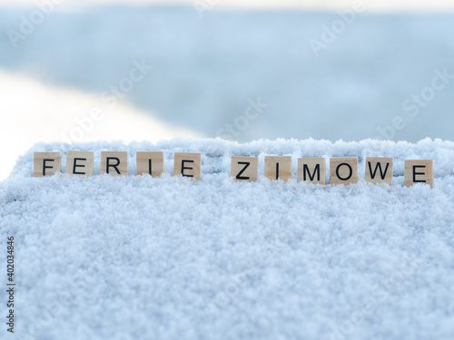 Ferie zimowe - napis z drewnianych kostek, ułożony w śniegu, czas wolny, przerwa zimowa od szkoły, język polski 