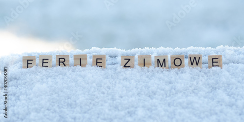 Ferie zimowe - napis z drewnianych kostek, ułożony w śniegu, czas wolny, przerwa zimowa od szkoły, język polski 