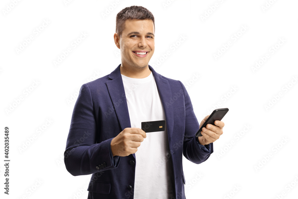 Young handsome man with a wide smile using a credit card for online payment with a mobile phone Young handsome man with a wide smile using a credit card for online payment with a mobile phone