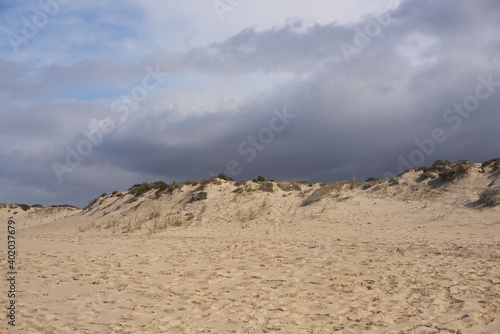 Sand dunes with nobody and a storm behind in Comporta, Portugal