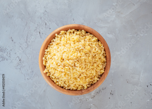 Raw bulgur grain in a bowl. Healthy, dietary, vegan, gluten free product. Healthy eating concept. Organic product made from wheat grains. Source of natural protein, fiber and fat. Top view. Soft focus
