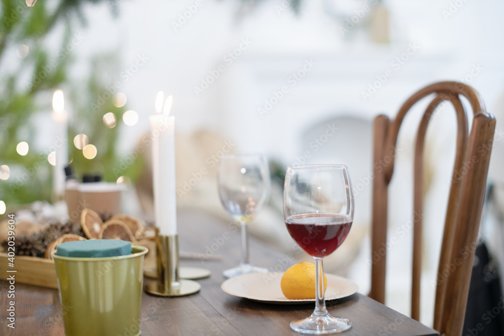 Festive Christmas atmosphere at home in a Scandinavian-style room on a table with candles and a Christmas tree.