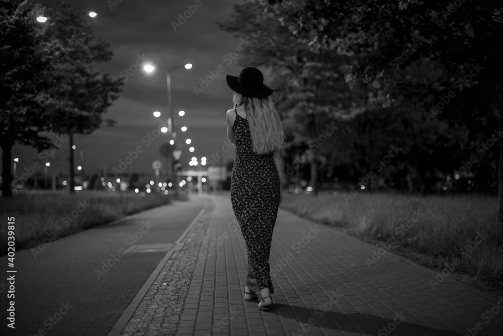 miasto ulica kobieta światłą miasta city noc nocne zdjęcie kapelusz  - obrazy, fototapety, plakaty 
