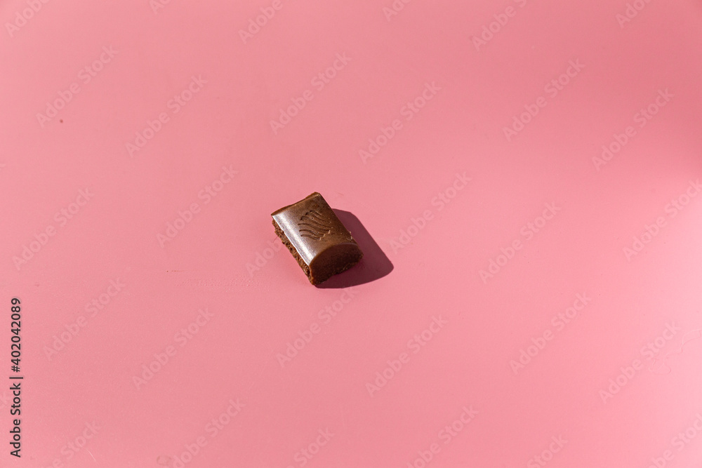 pieces of chocolate on a pink background with hard light pieces of chocolate on a pink background with hard light