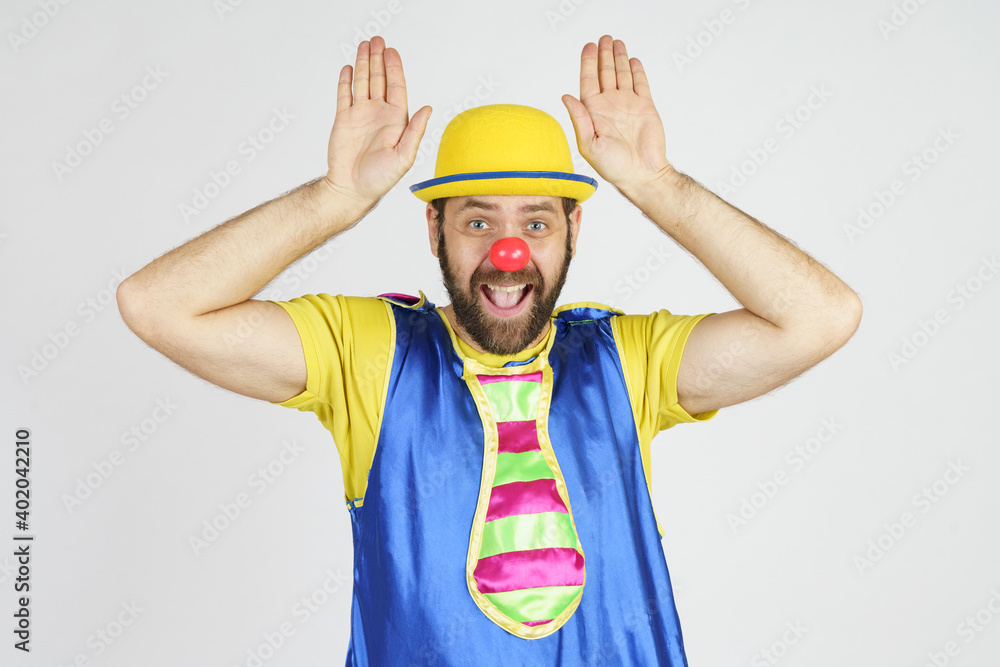 Clown in a bright blue and yellow suit shows hand gestures Clown in a bright blue and yellow suit shows hand gestures