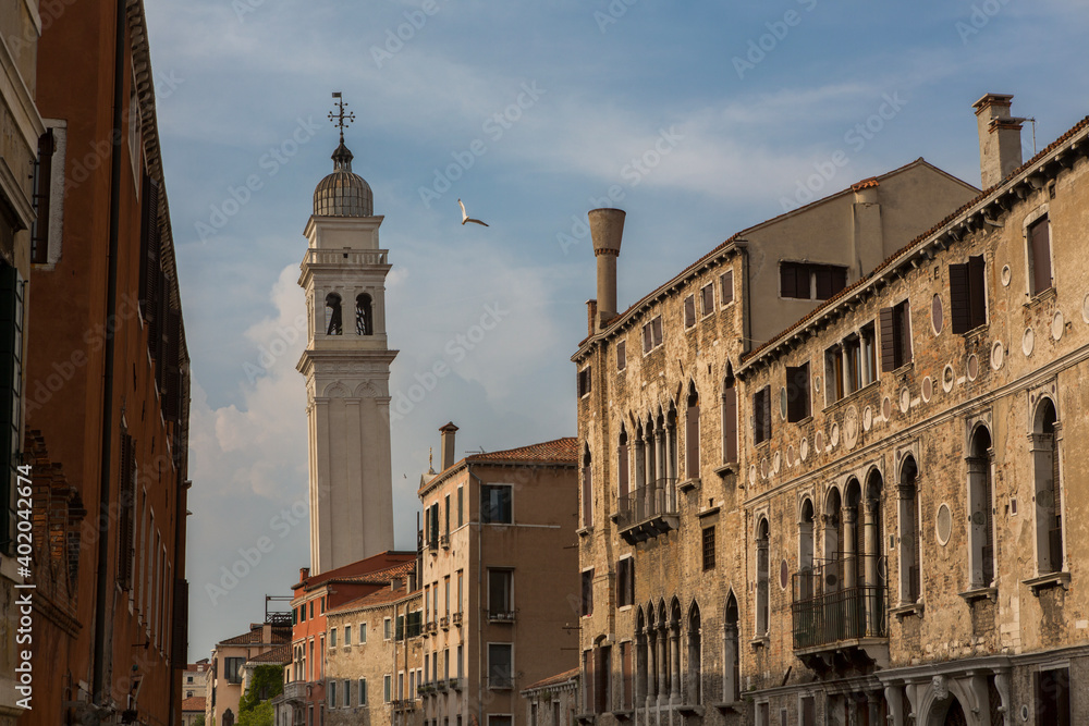 A seagull flies past the leaning bell tower of the Campanile of San Giorgio dei Greci, in Venice, Italy. This is one of 10 leaning towers in the whole of Italy. 