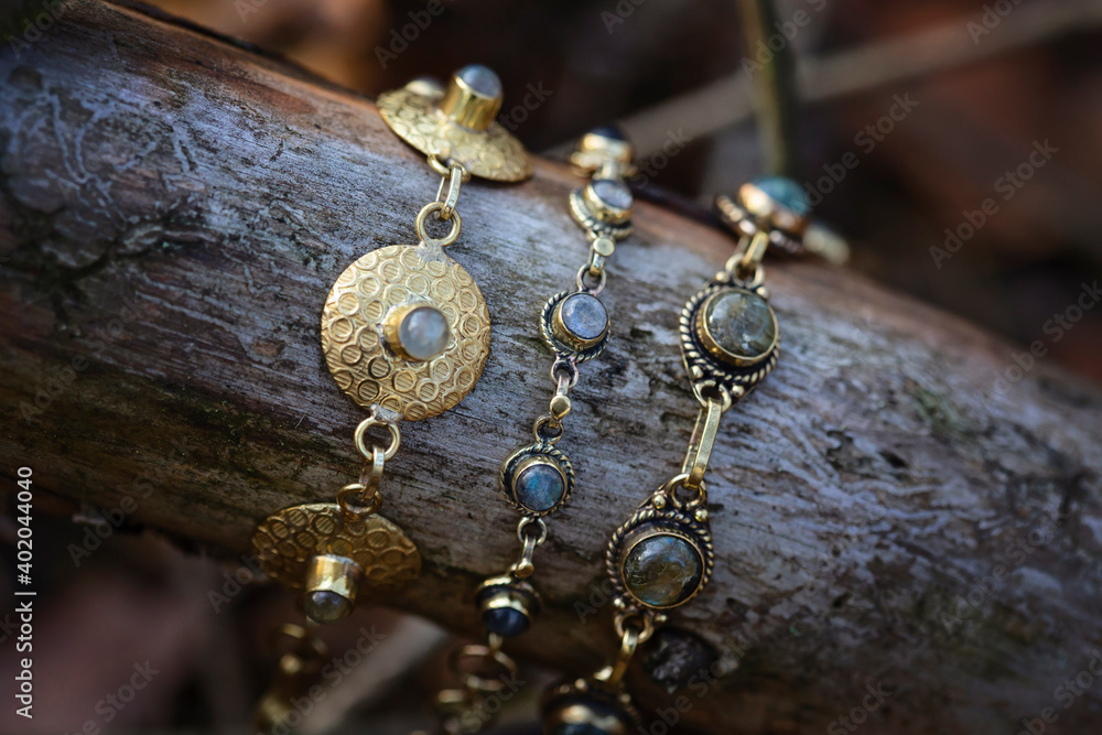 Fototapeta premium Three brass bracelets with labradorite stone on wooden background