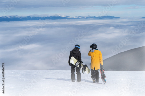  Two snowboarders talking while walking on the mountain