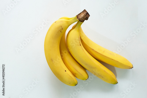 bunch of semi ripe cavendish bananas on white background. top view photo. 