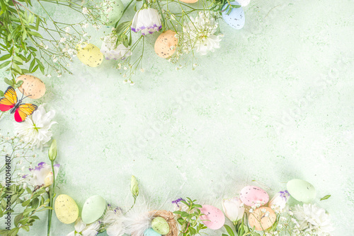 Happy Easter concept. Spring Easter holiday top view  flat lay background with easter eggs in nests and spring flowers. Easter greeting card background with copy space.
