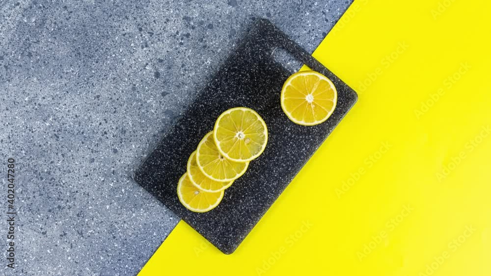 Creative stop motion of Ultimate Gray and Illuminating trending color food background. Lemon and cutting board on gray and yellow table surface. Creative stop motion of Ultimate Gray and Illuminating trending color food background. Lemon and cutting board on gray and yellow table surface.