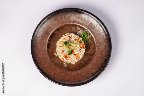 Basmati rice with fried carrots, onions, mushrooms, broccoli vegetables in butter on a white background