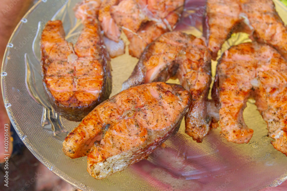 Grilled red fish trout steaks lie on a glass plate