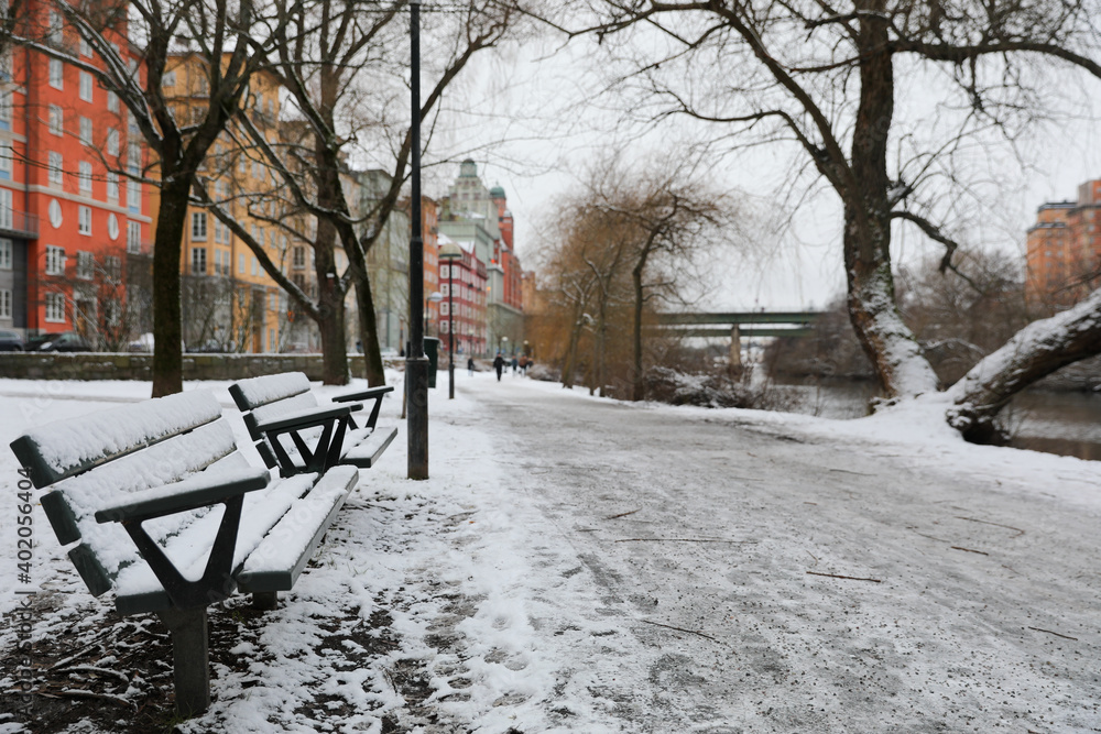 Snow covered benches by river path Snow covered benches by river path