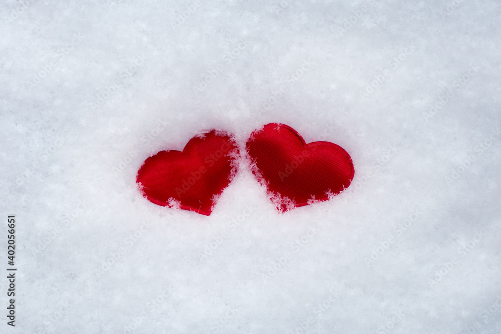 two little hearts in the snow. symbol of love and loyalty, Valentine's Day. Horizontal photo.
