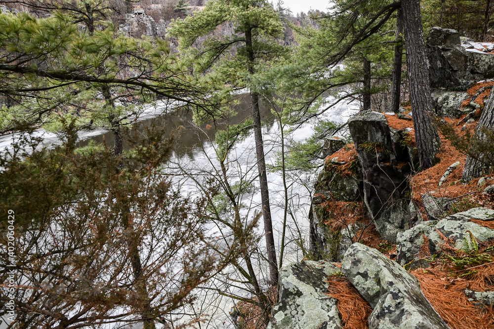 Rocky cliffs along the winter snow and icy river Rocky cliffs along the winter snow and icy river