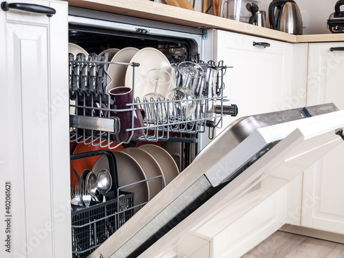 Фотография dishwasher close-up with washed dishes, easy to use and save water, eco-friendly