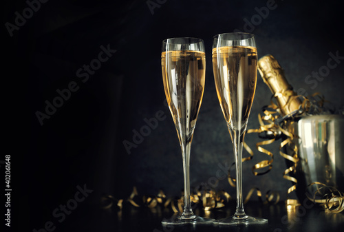 Champagne with two glasses, golden serpentine decoration, copy space