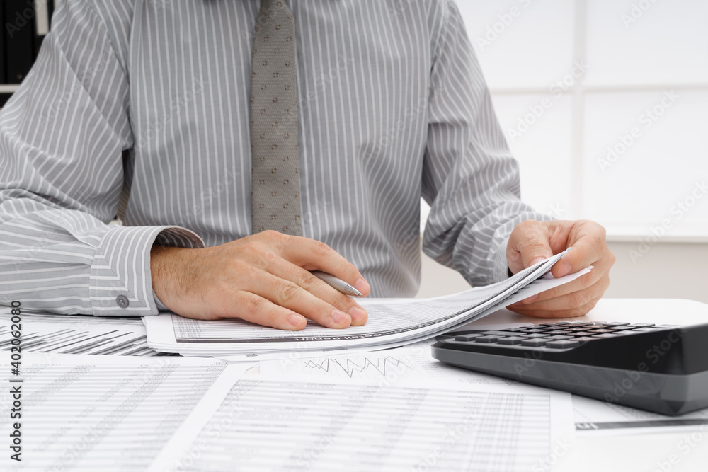 Fototapeta premium business concept - businessman's working table close view, checks financial reports, writes and counts