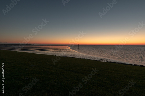 Valokuva An orange shaded beautiful sunset on a boundless sea in Norderney