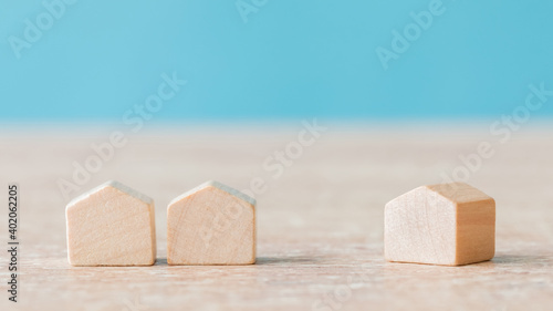 Obraz na plátně A selective focus of wooden house miniatures on blue background