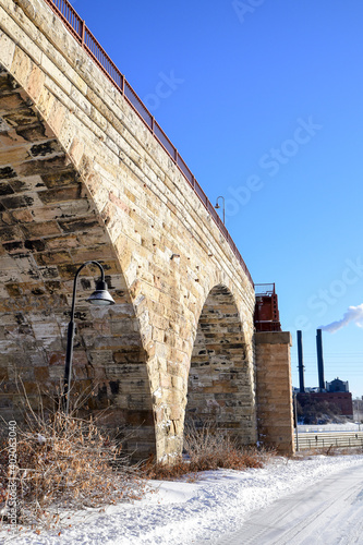 Vintage and historic city stone bridge over the river in winter