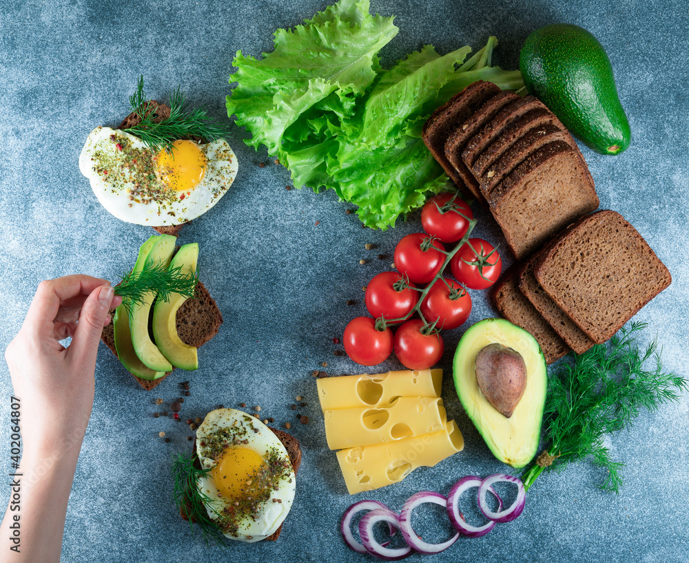 avocado, egg sandwiches on whole grain bread with tri-colored tomatoes on rustic baking tray avocado, egg sandwiches on whole grain bread with tri-colored tomatoes on rustic baking tray