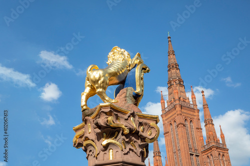 Golden Nassau Lion on Marktbrunnen in Wiesbaden with top of Marktkirche - market church