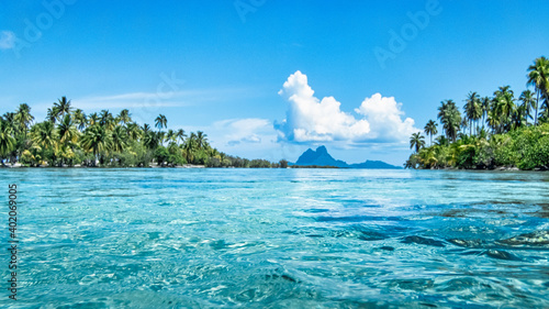 Fotografia Vibrant turquoise water scene in French Polynesia with Bora Boa in the distance