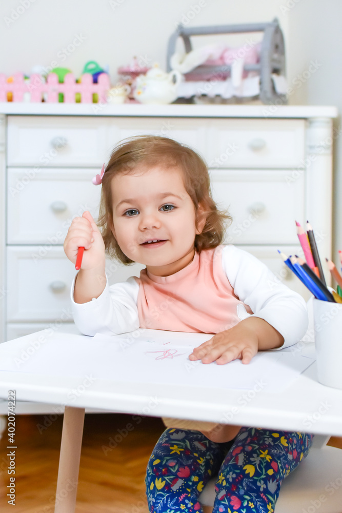 Cute adorable baby girl drawing a picture with colored pencil at home or kindergarten. Toddler child painting on paper. Kid playing in nursery. Cute adorable baby girl drawing a picture with colored pencil at home or kindergarten. Toddler child painting on paper. Kid playing in nursery.