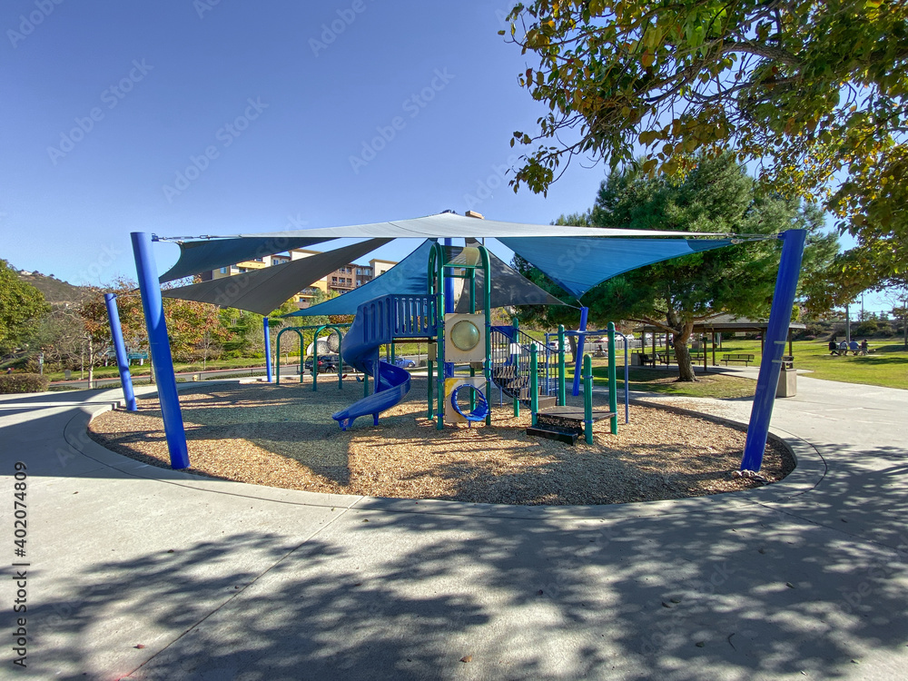 Children playground activities in public park. Slide, swing on modern playground. Urban neighborhood childhood concept. Children playground activities in public park. Slide, swing on modern playground. Urban neighborhood childhood concept.