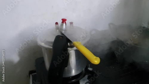 Pressure cooker on fire stove, cooking process in household or commercial kitchen