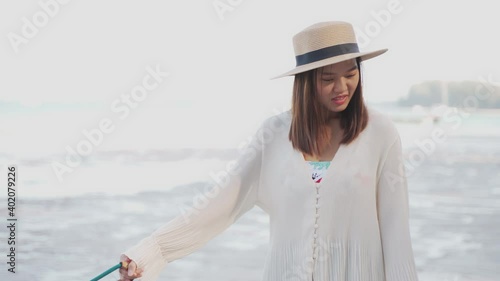The beauty lady is leading dogs at the beach in sunny day. She is not smile because the dogs are stubborn which are their first time on the beach