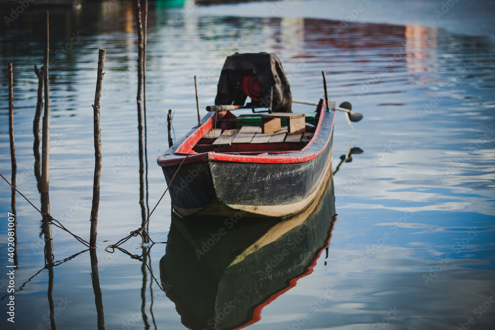Obraz premium old wooden boat floating over plain water