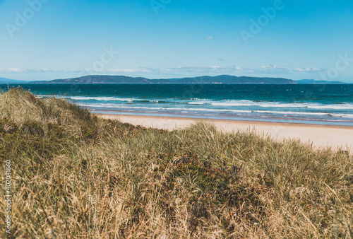 Fototapeta Naklejka Na Ścianę i Meble -  pristine wild landscape at Clifton Beach in Tasmania, Australia with wavy blue ocean and golden sand next to a rugged coastline