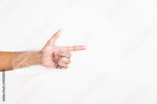 Woman hand wearing single use protect disposable transparent plastic glove with point finger sign gesture, studio shot isolated on white background