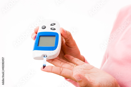 Closeup hands woman measur glucose test level check with blood on finger by glucometer she monitor and control high blood sugar diabetes and glycemic health care concept isolated on white background